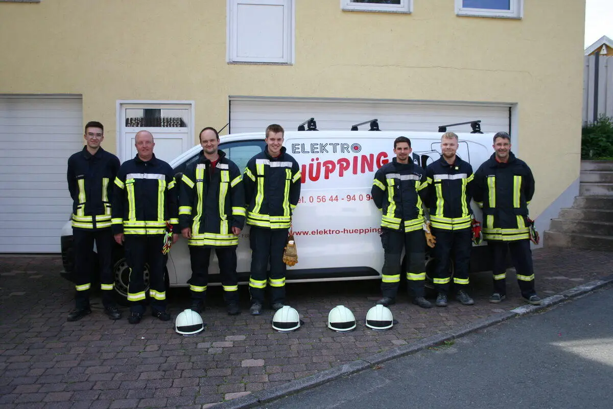 Das Team von Elektro Hüpping in Einsatzkleidung der Freiwilligen Feuerwehr